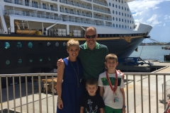 Family photo outside Disney Cruiseline Terminal in front of Disney Fantasy