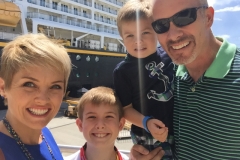 Family photo outside Disney Cruiseline Terminal in front of Disney Fantasy